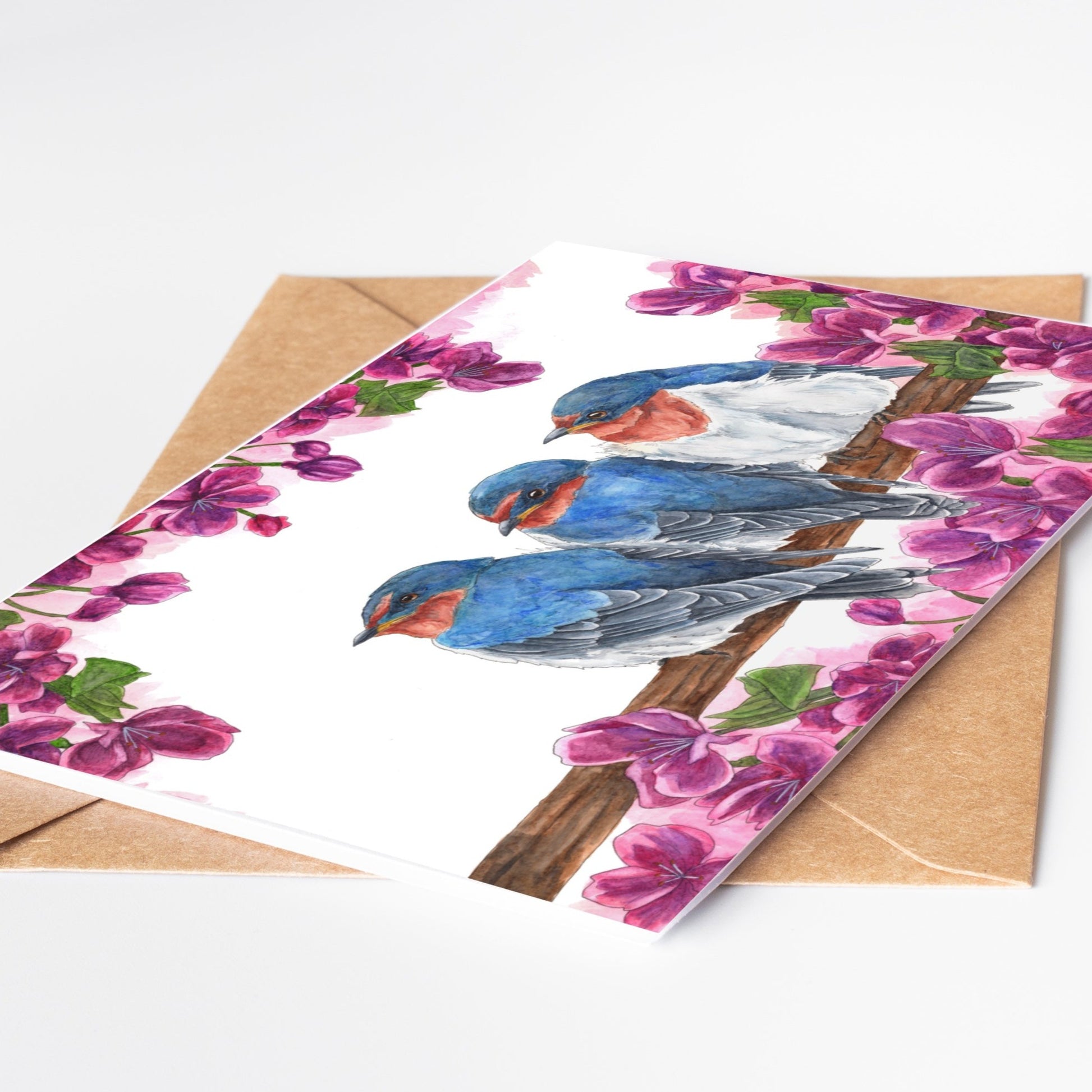 Greeting card by artist Leah Ingram featuring 3 Swallows on a branch surrounded by purple flowers.