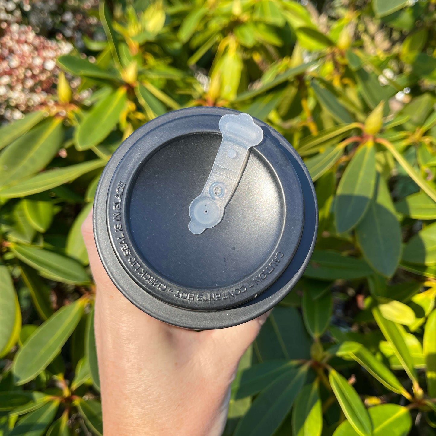 Top of a travel coffee mug showing the sipper top.