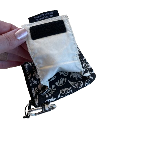 Black purse with white floral and owl print, showing the extra pouch on the back.