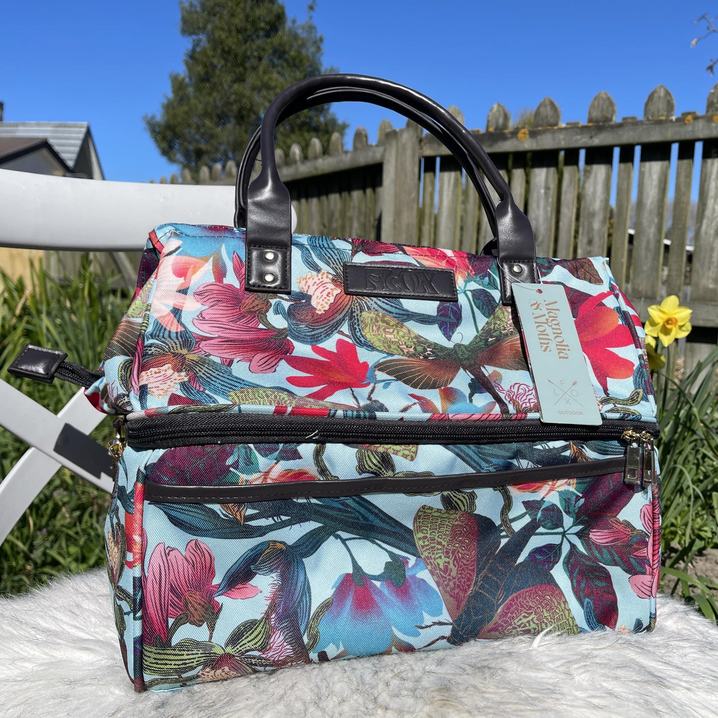 Colourful picnic cooler bag with teal blue background and magnolia flower print.