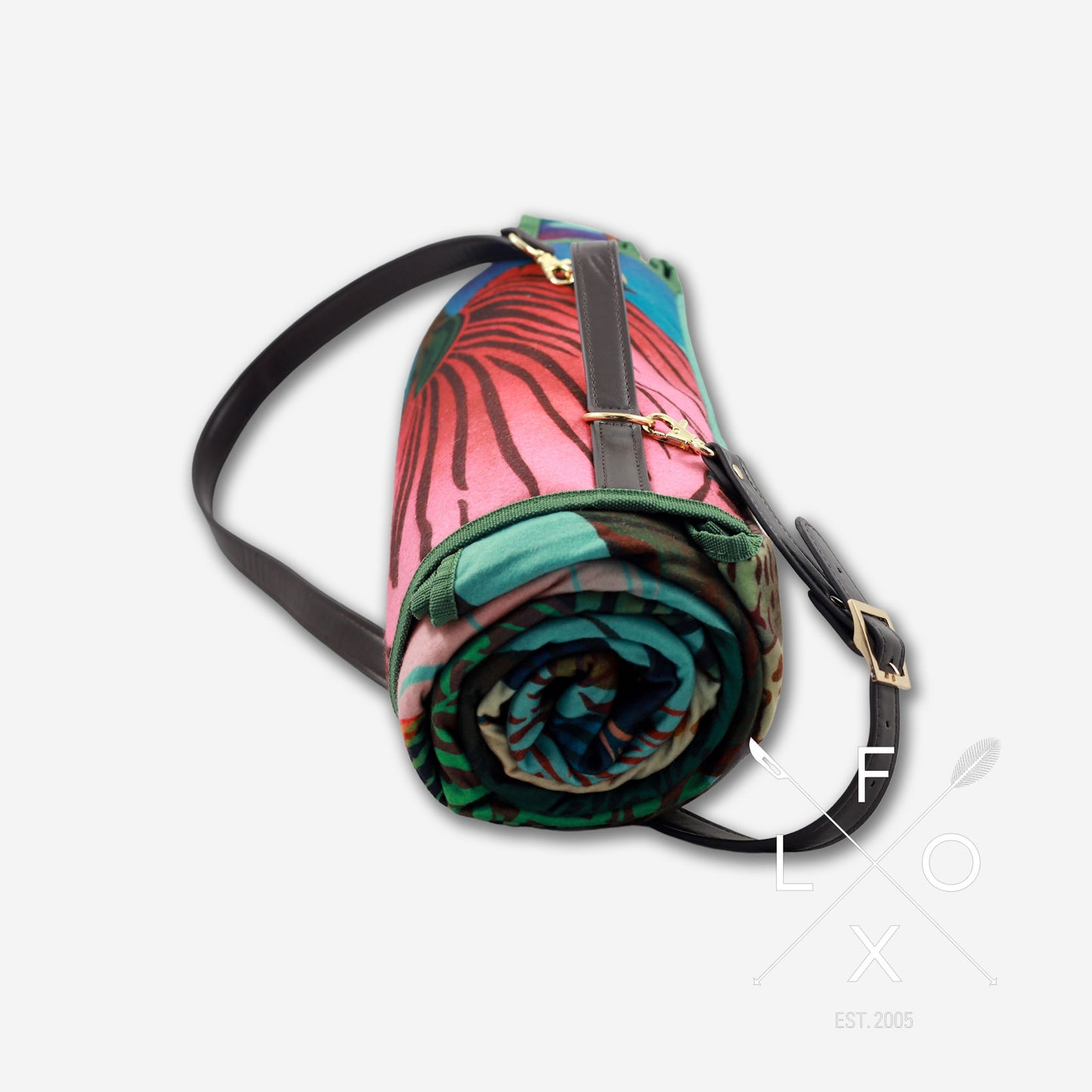 Colourful picnic blanket rolled up with straps.