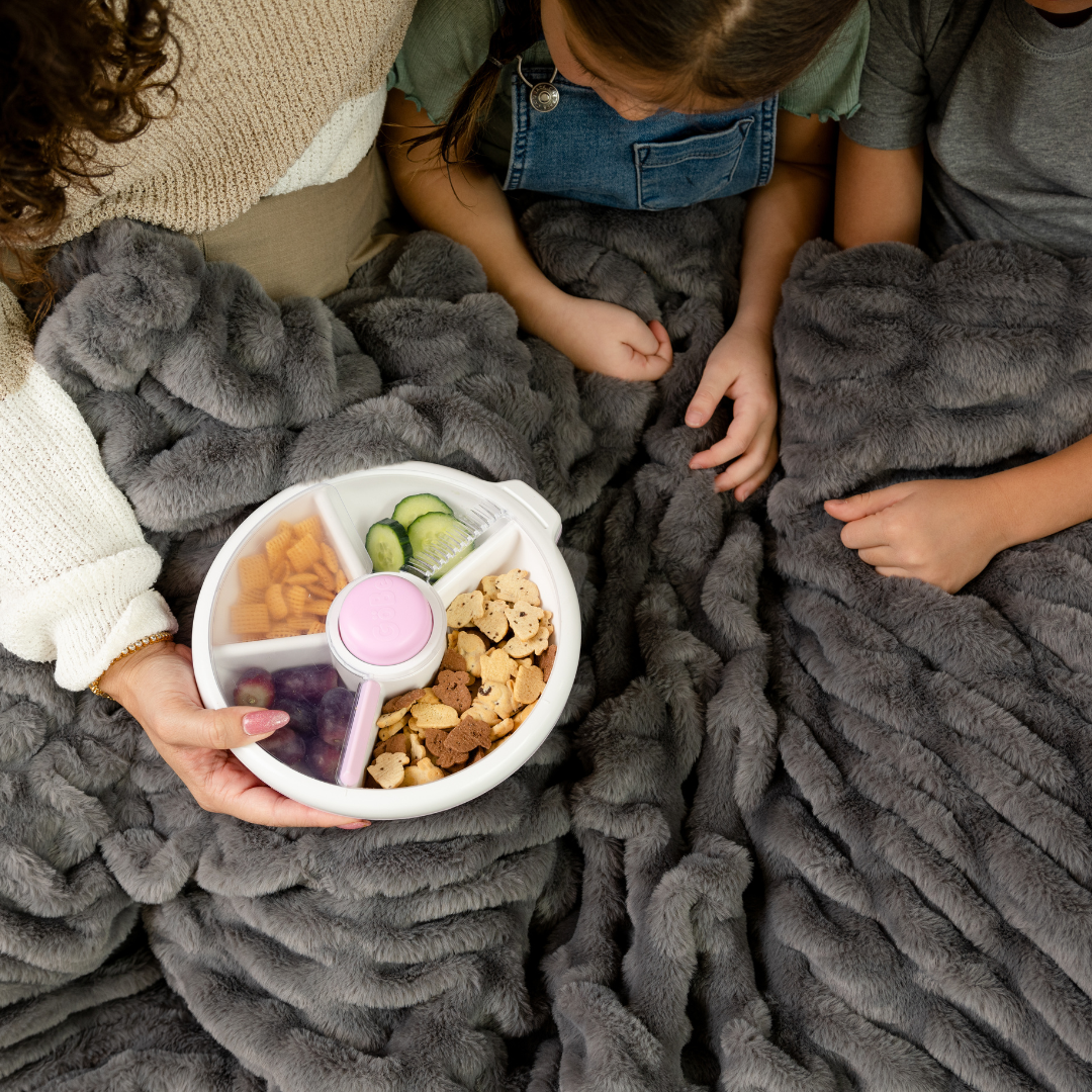 Children using a Gobe snack spinner lunch box in light purple & white..