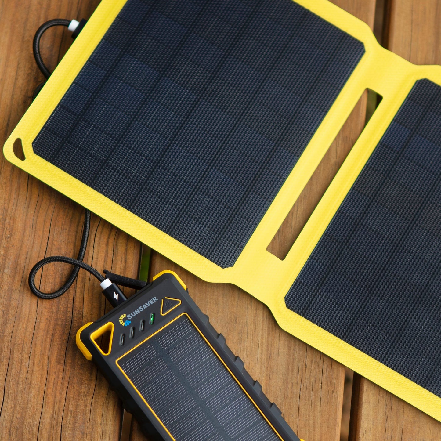 Powerboost portable solar panel and with carabiners for attachment. Charging another portable power bank.