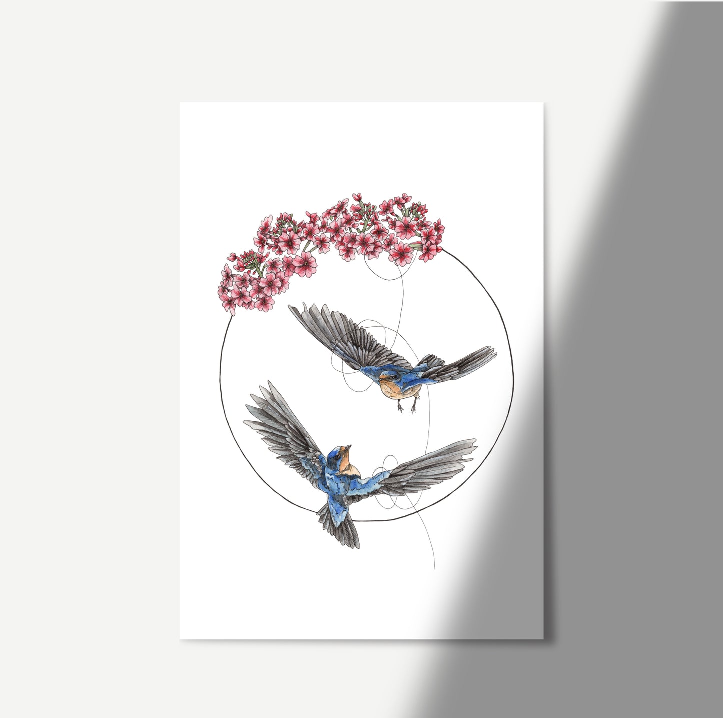 Watercolour art featuring 2 swallows flying together tethered by a string in a circle and topped with primrose flowers.