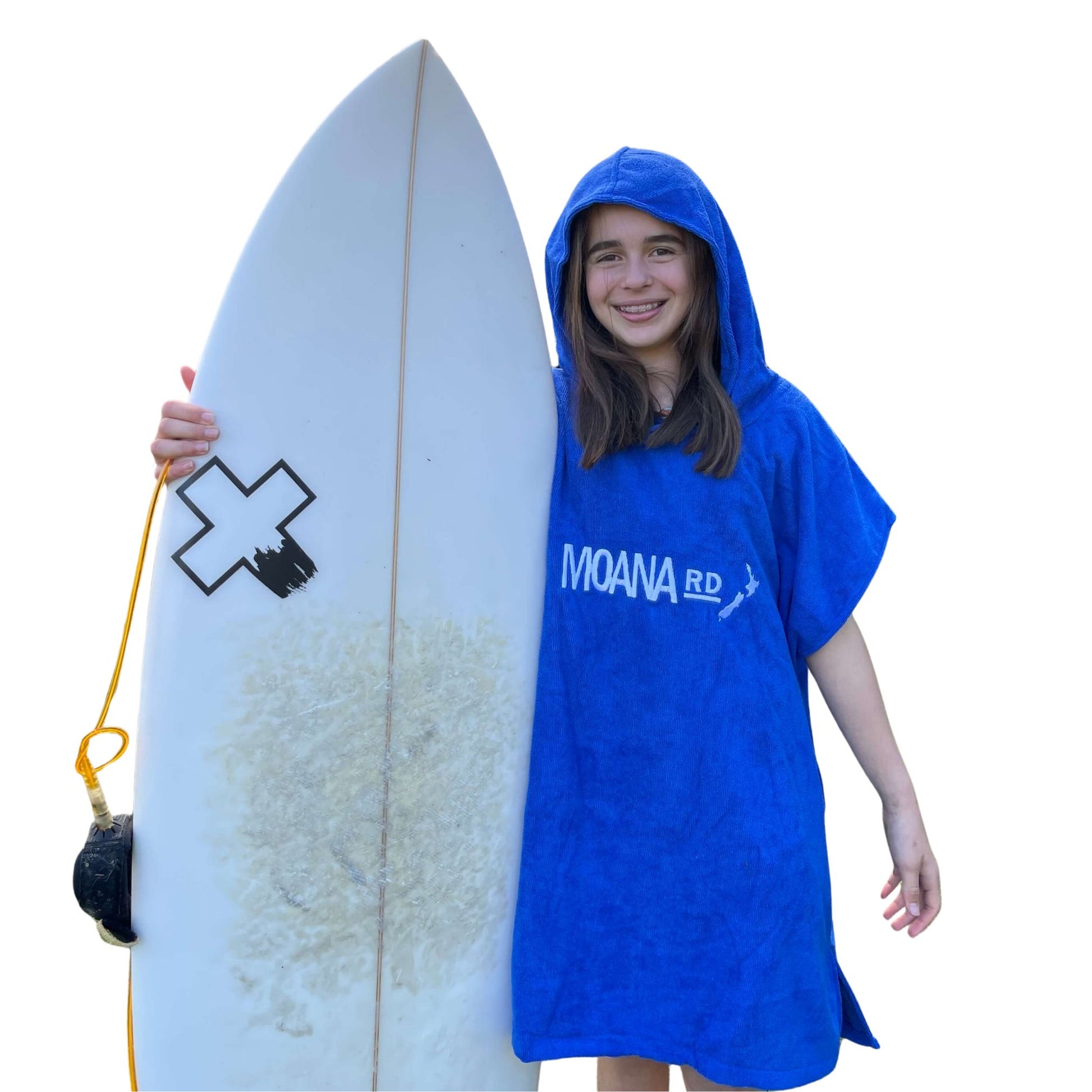 Young girl wearing a blue towel hoodie with the words Moana RD on it in white and a map of New Zealand. She is holding a surfboard.