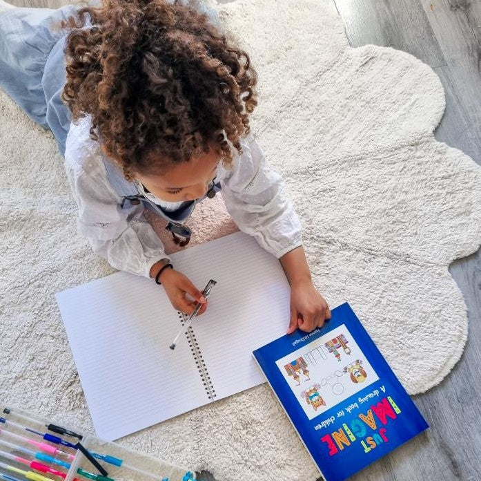 Child drawing using an art guide book.