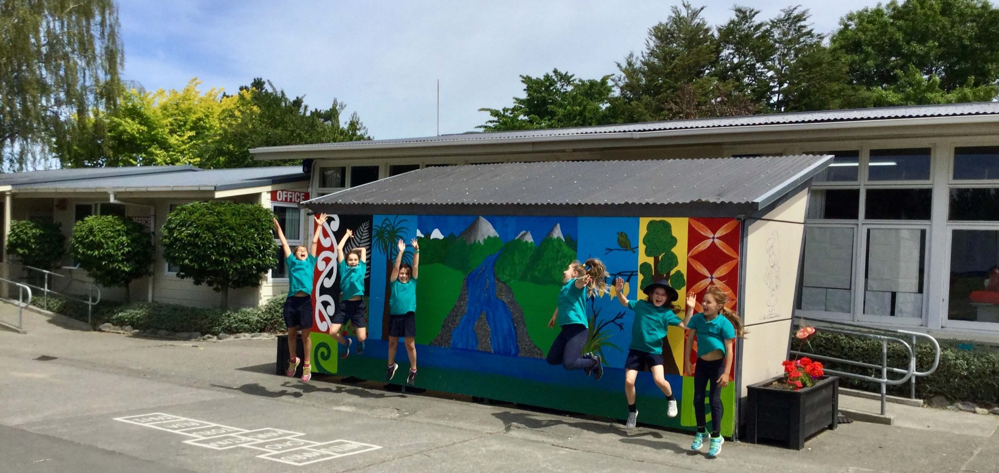 School fundraising shop banner image with scholl children jumping outside school