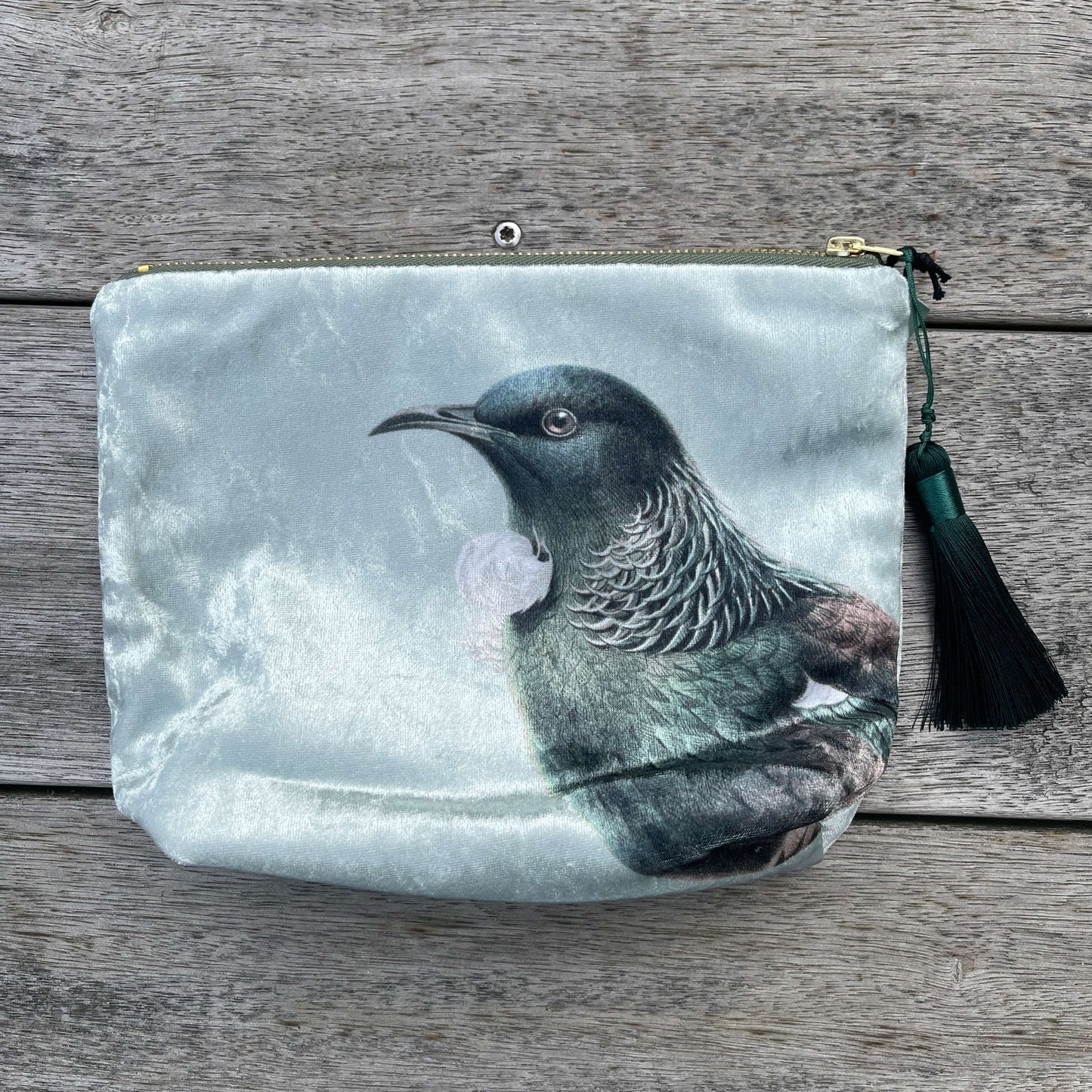 Velvet cosmetic bag featuring the head of a Tui bird.