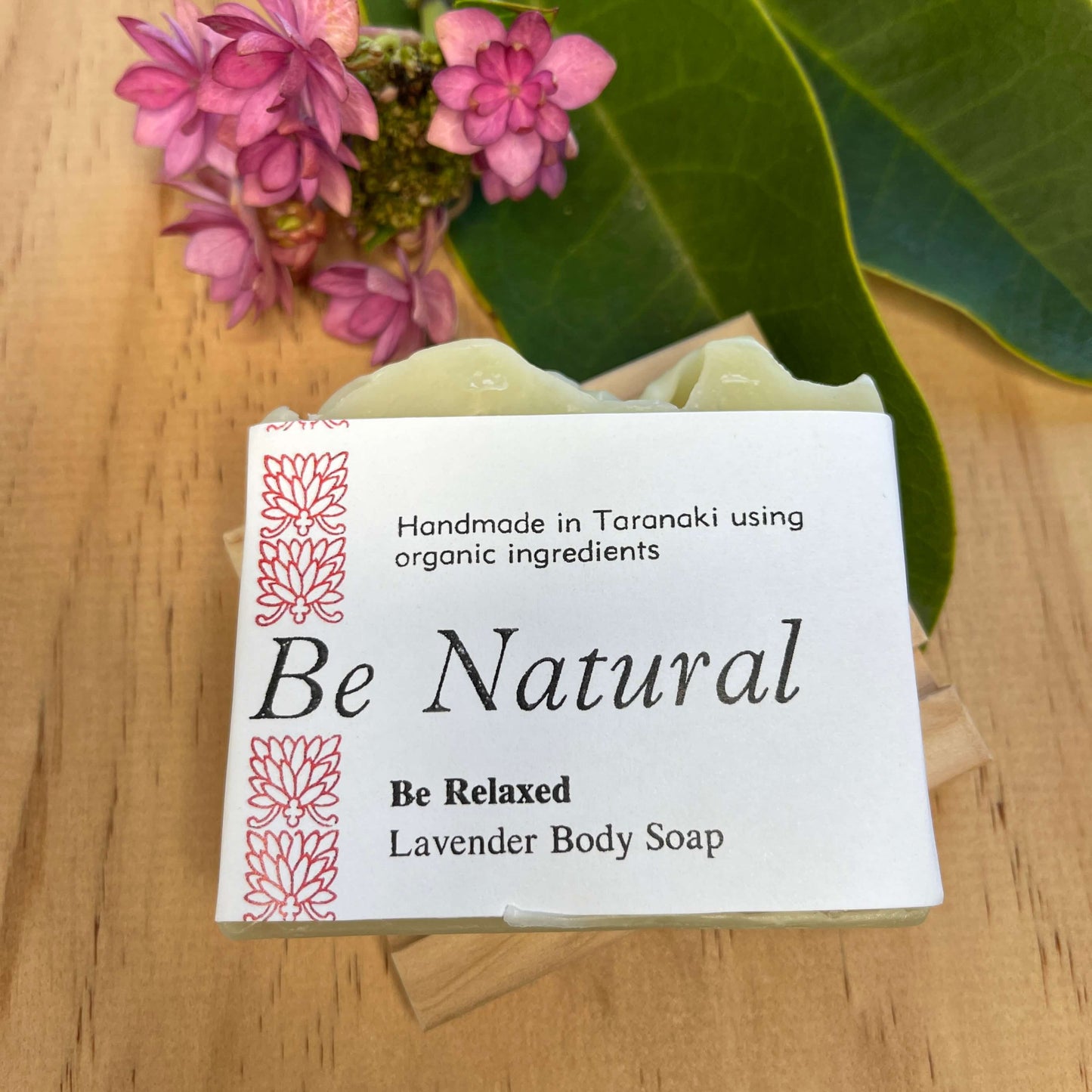 Lavender body soap on a wooden soap dish.