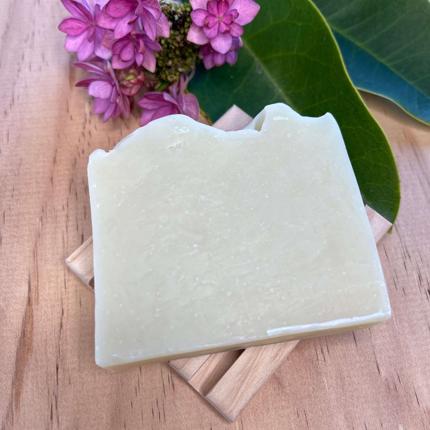 Lavender body soap on a wooden soap dish.