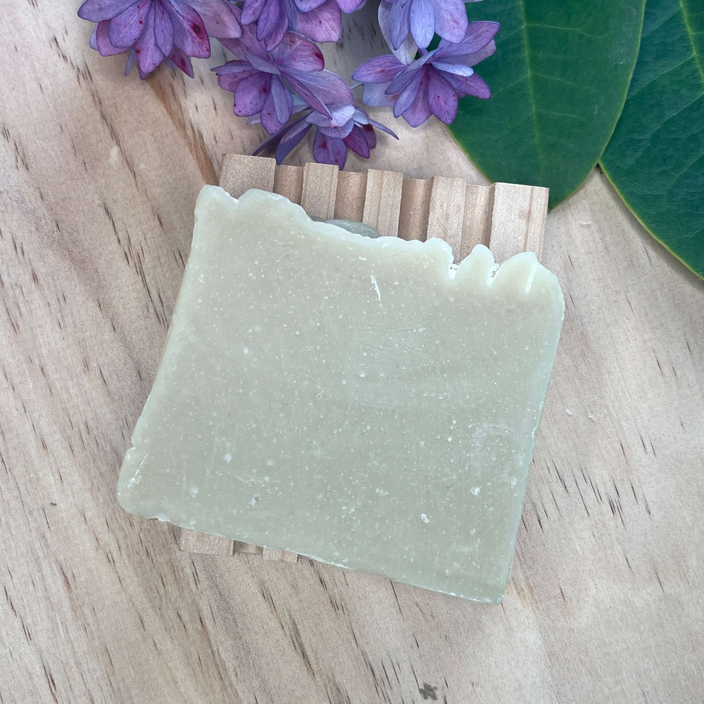 Natural shampoo bar on a wooden soap rack.