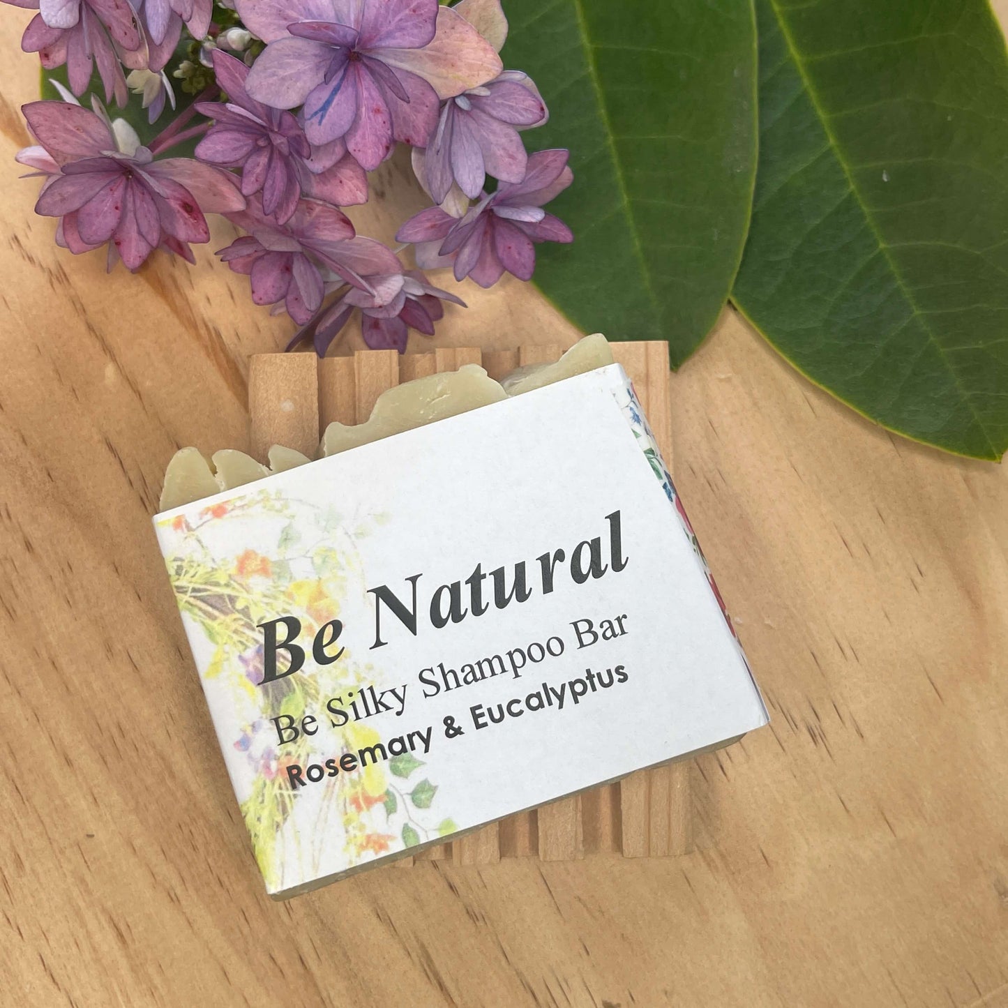 Natural shampoo bar on a wooden soap rack.