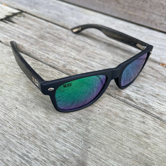 Sunglasses with dark wooden arms, black frames and green reflective lenses.