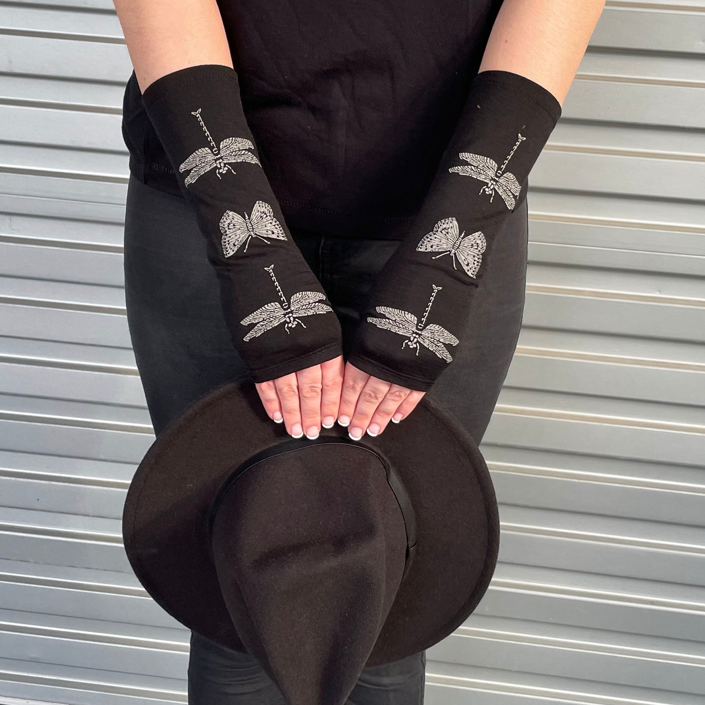 Fingerless merino gloves in black with dragonfly print.
