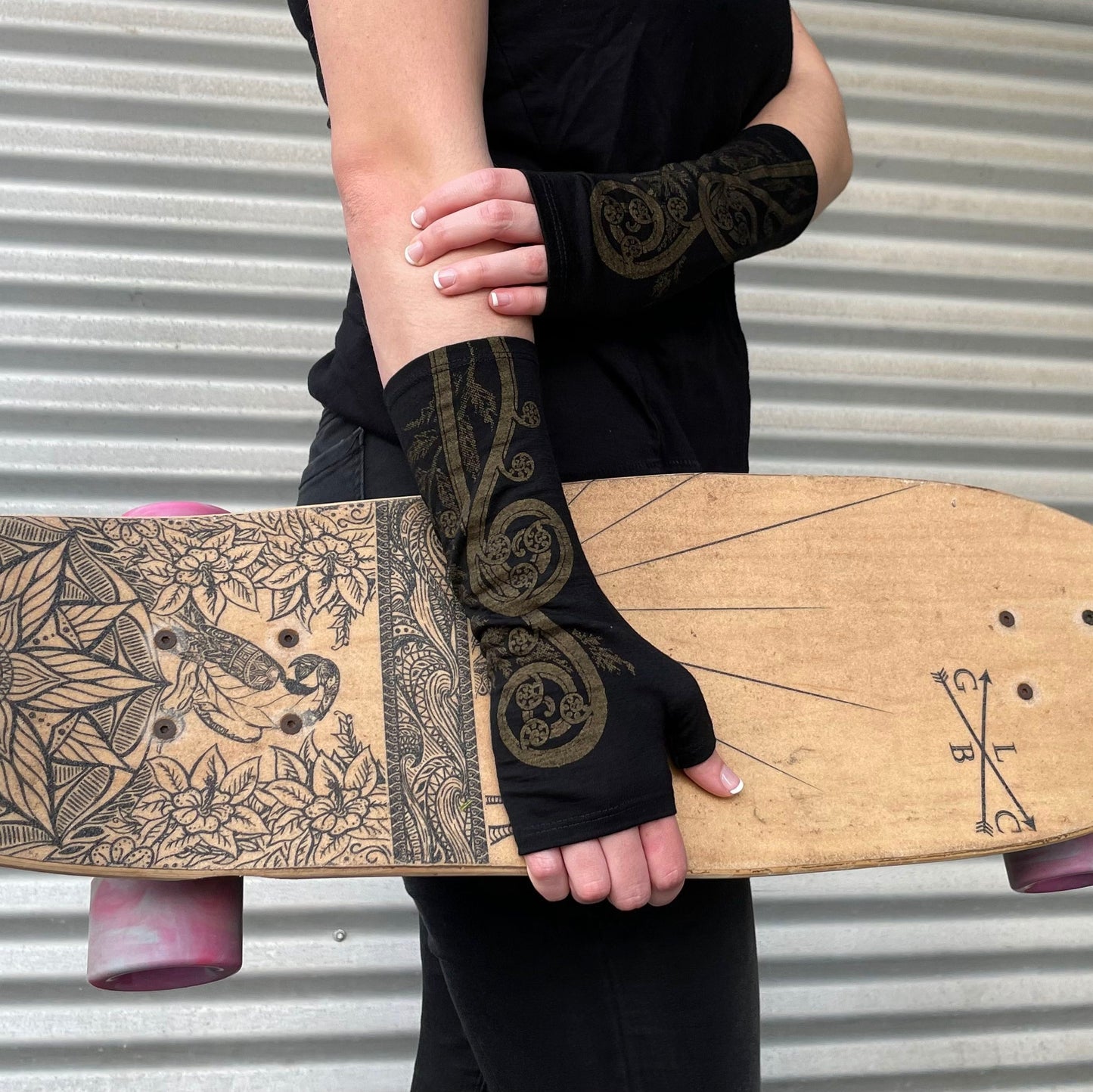 Fingerless merino gloves in black with gold fern print.
