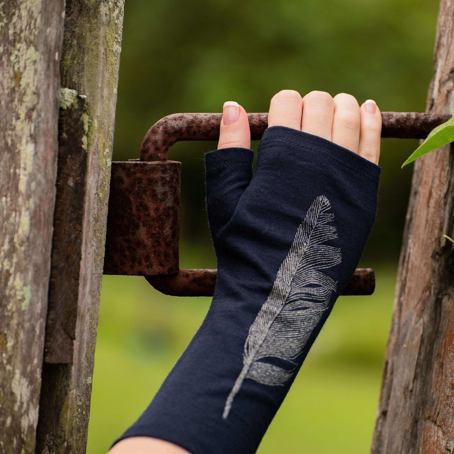 Fingerless merino gloves in black with silver feather print.