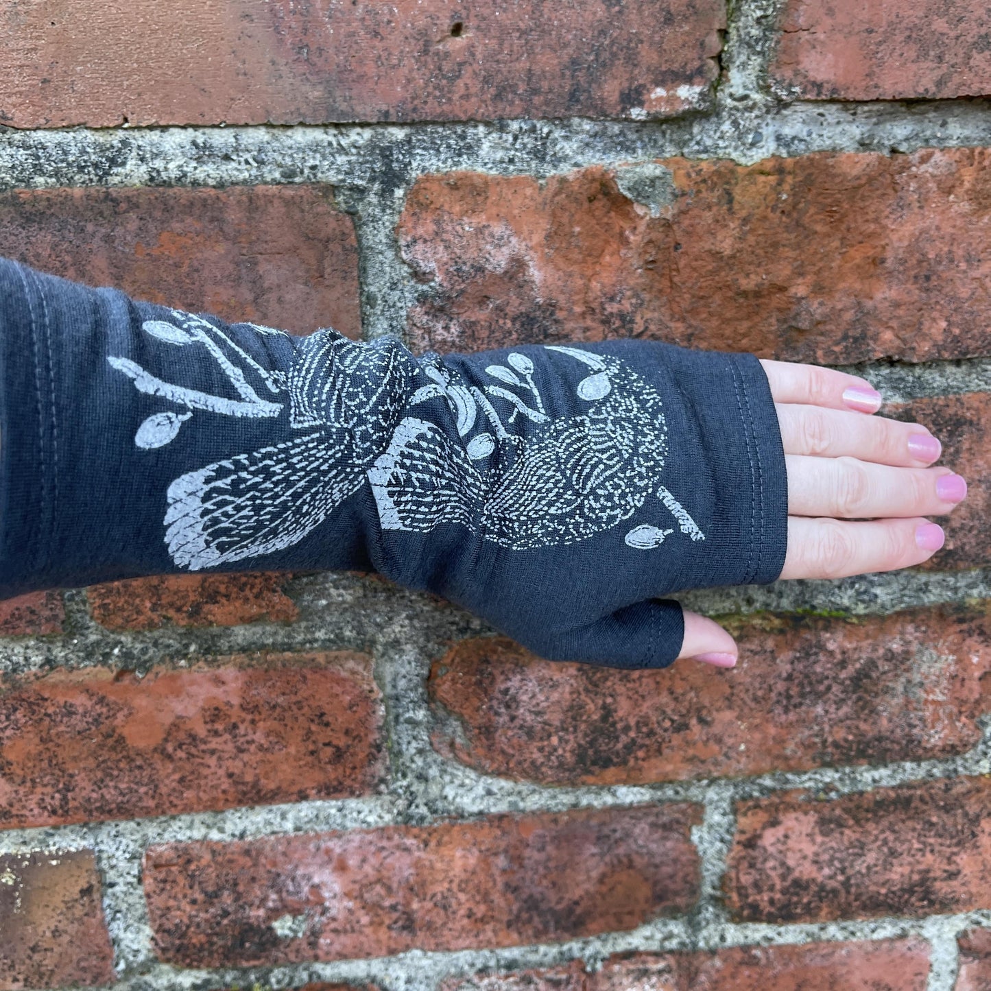 Fingerless merino gloves in charcoal with grey Huia bird print.