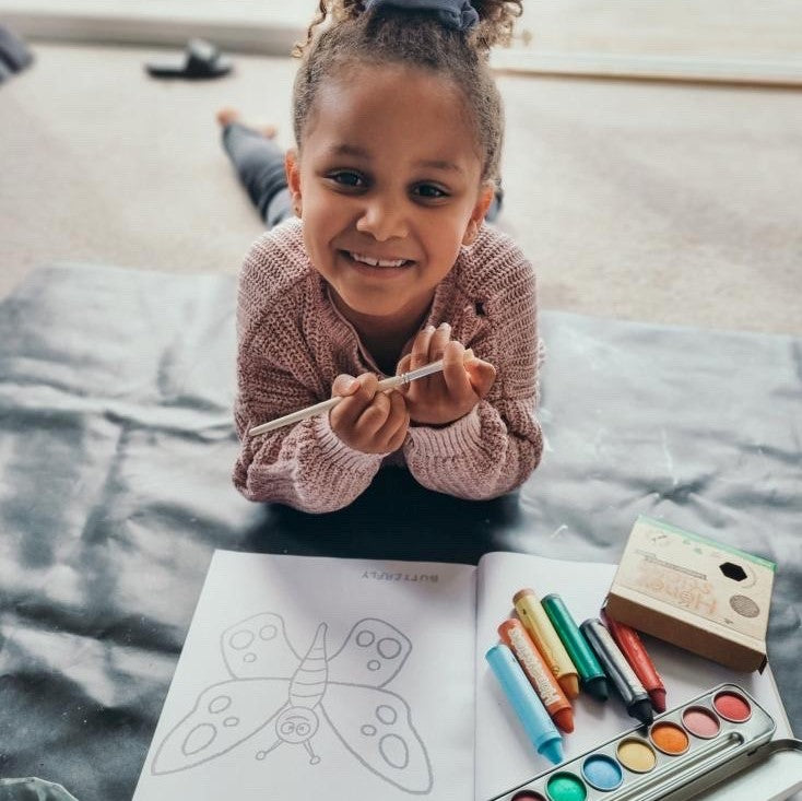 Child with Honeysticks colouring book and crayons and paints.