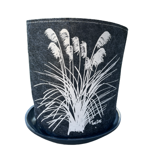 Dark grey felt planter with white toetoe plant printed on it sitting in a grey saucer.