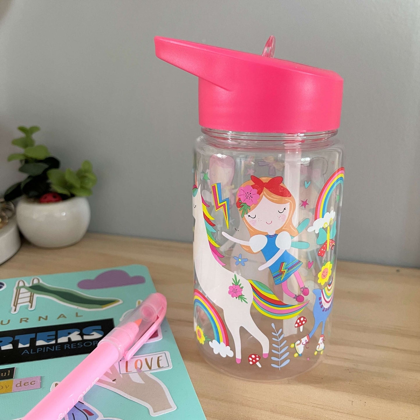 Kids drink bottle with fairies printed on it. Features bright pink lid with clear sipping tube.