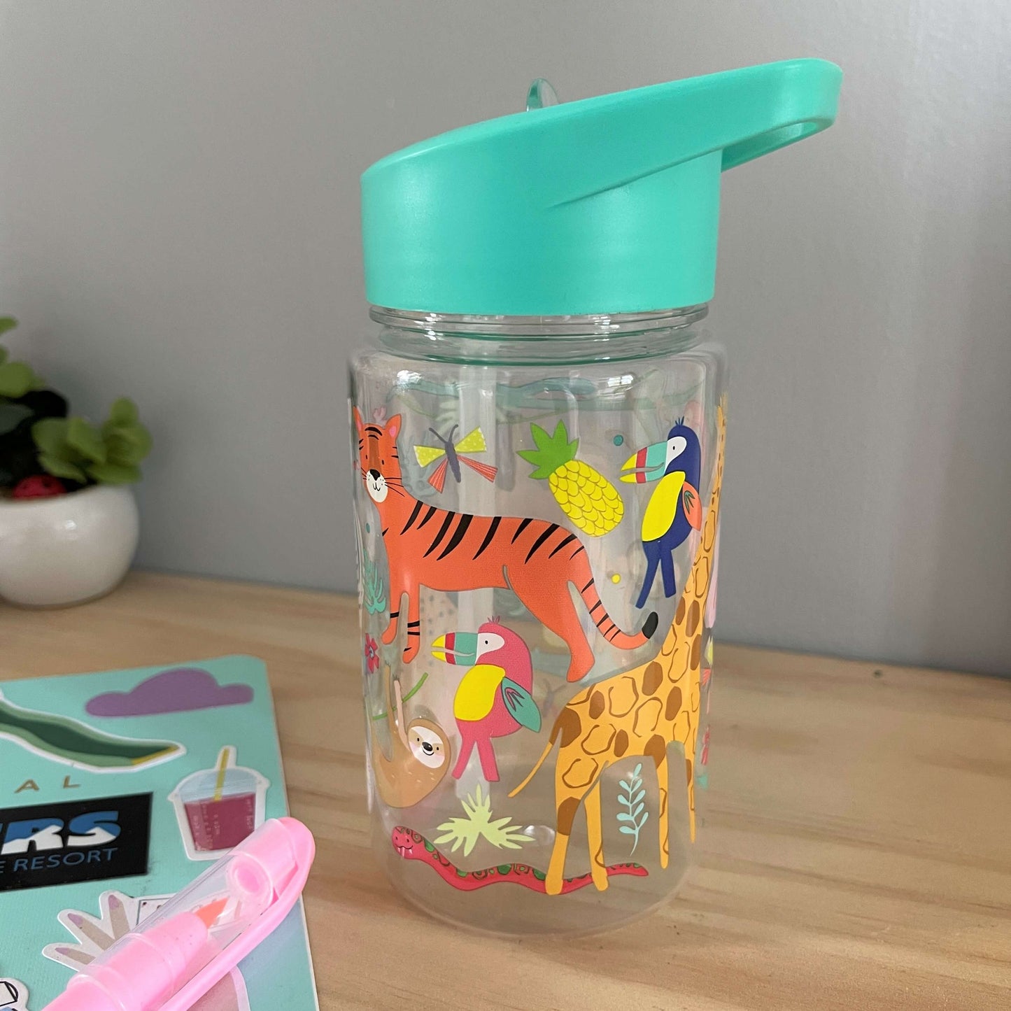 Kids drink bottle with jungle animals printed on it. Features aqua blue lid with clear sipping tube.