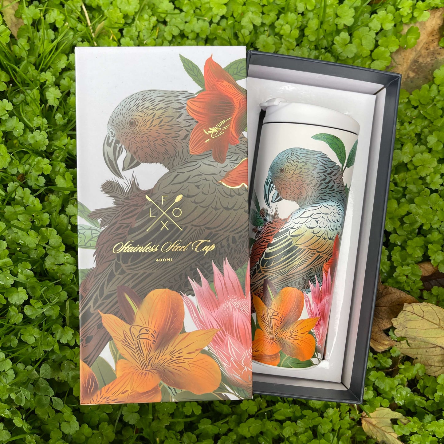 Stainless steel cup with Kaka bird and floral artwork by designer Flox sitting in a deluxe box featuring the same design.