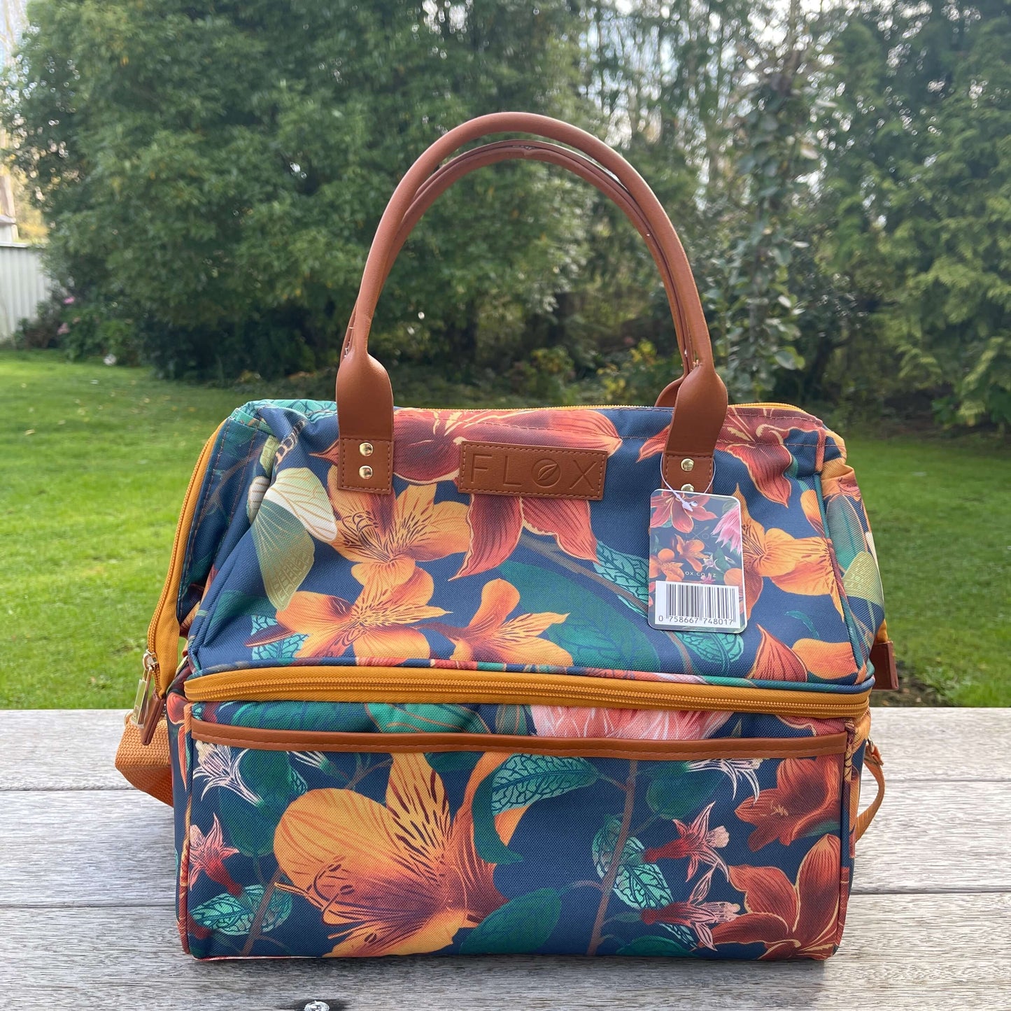 Large navy and orange floral fabric cooler bag sitting on a deck.