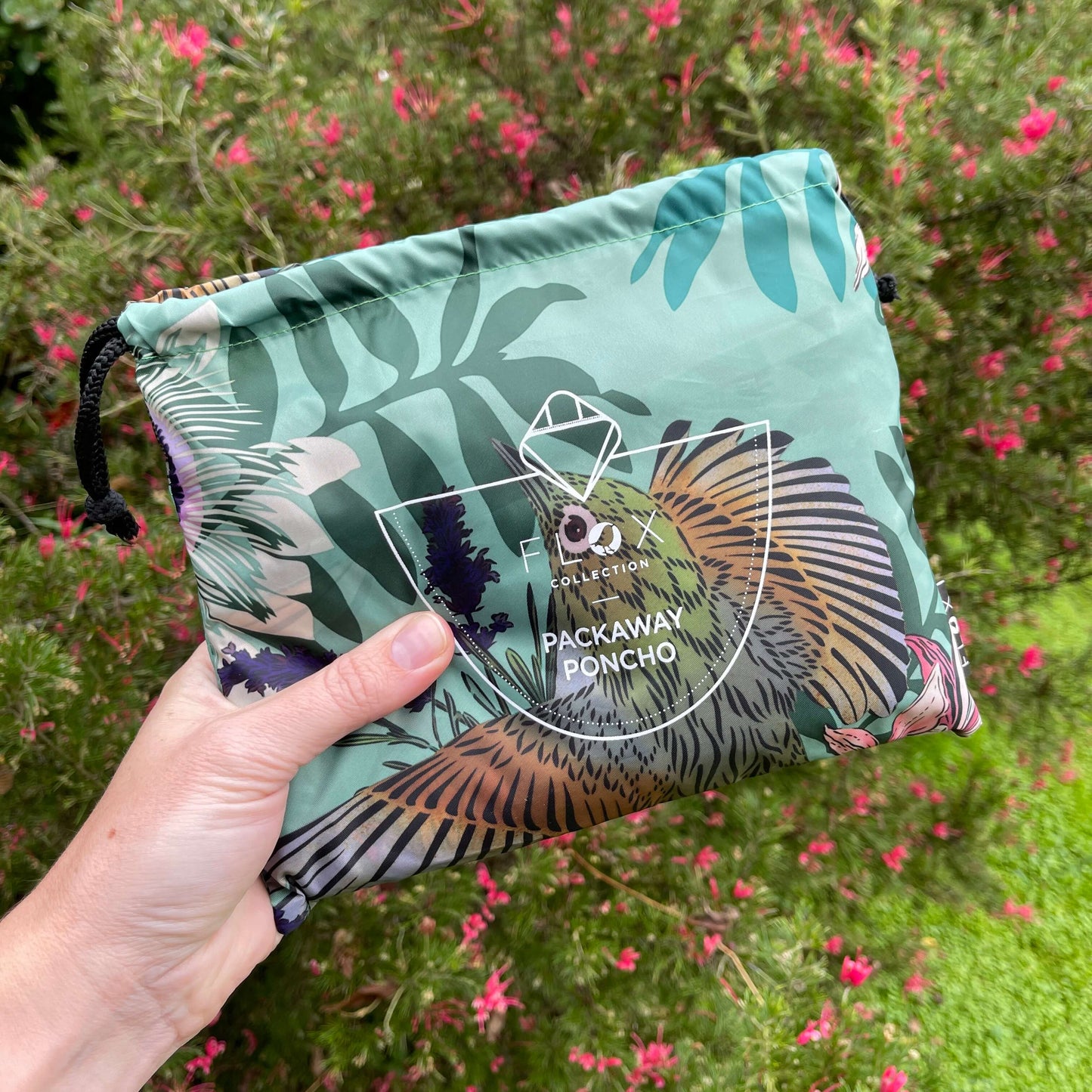 Hand holding a pouch for a rain poncho.