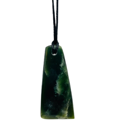Greenstone freeform pendant on a black wax cord draped over a rock.