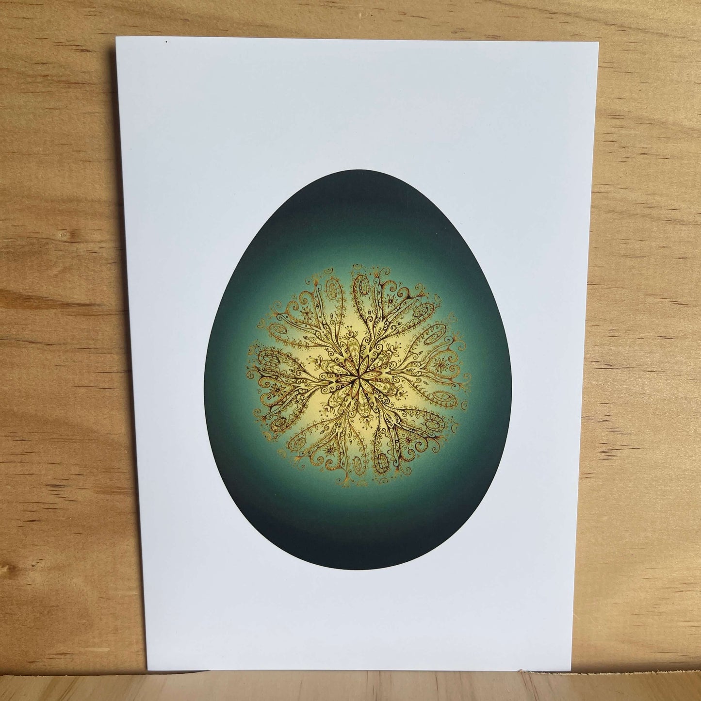 Greeting card with greenstone themed egg and gold vine pattern inside egg.