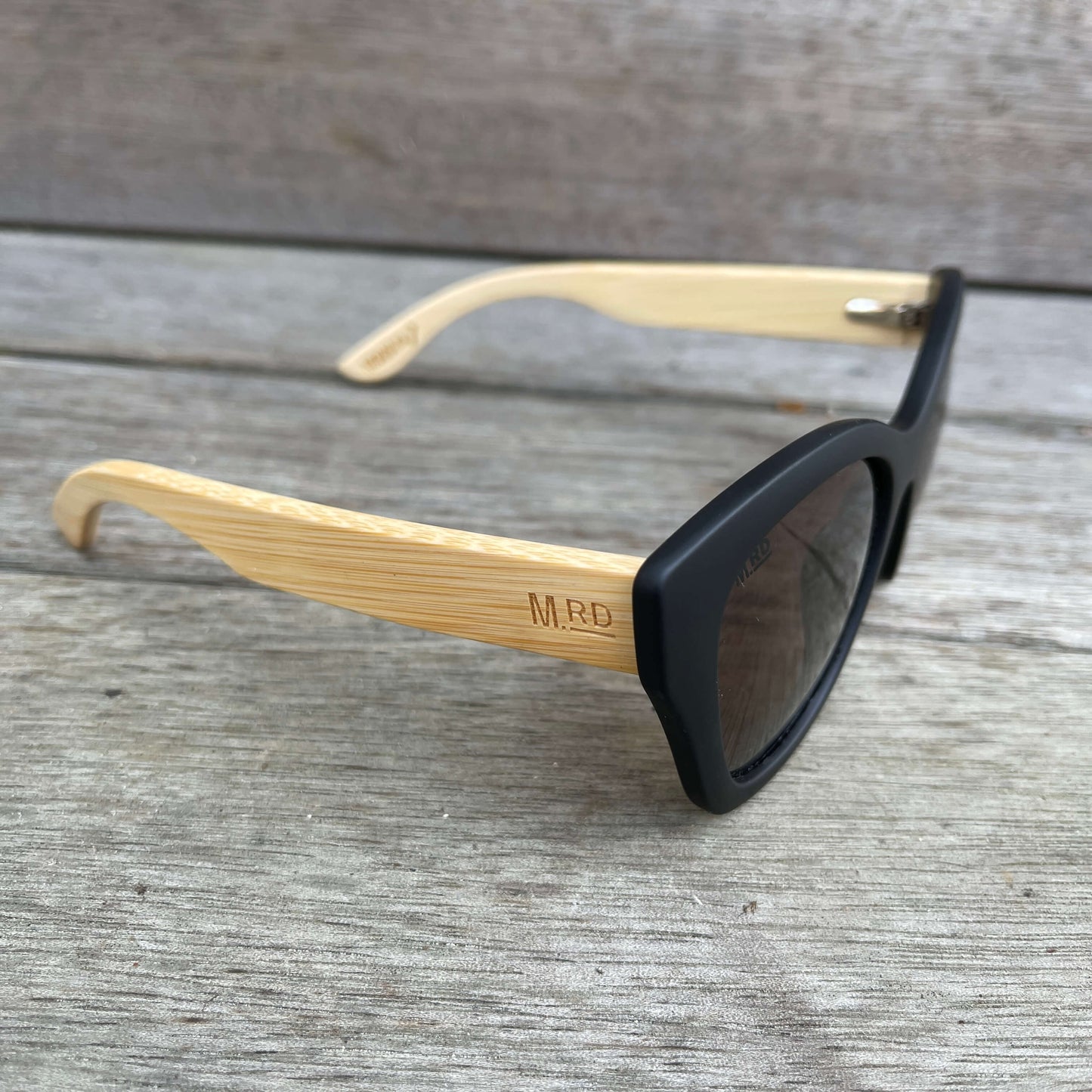 Womens sunglasses with black frames and wooden arms, in an Audrey Hepburn style.