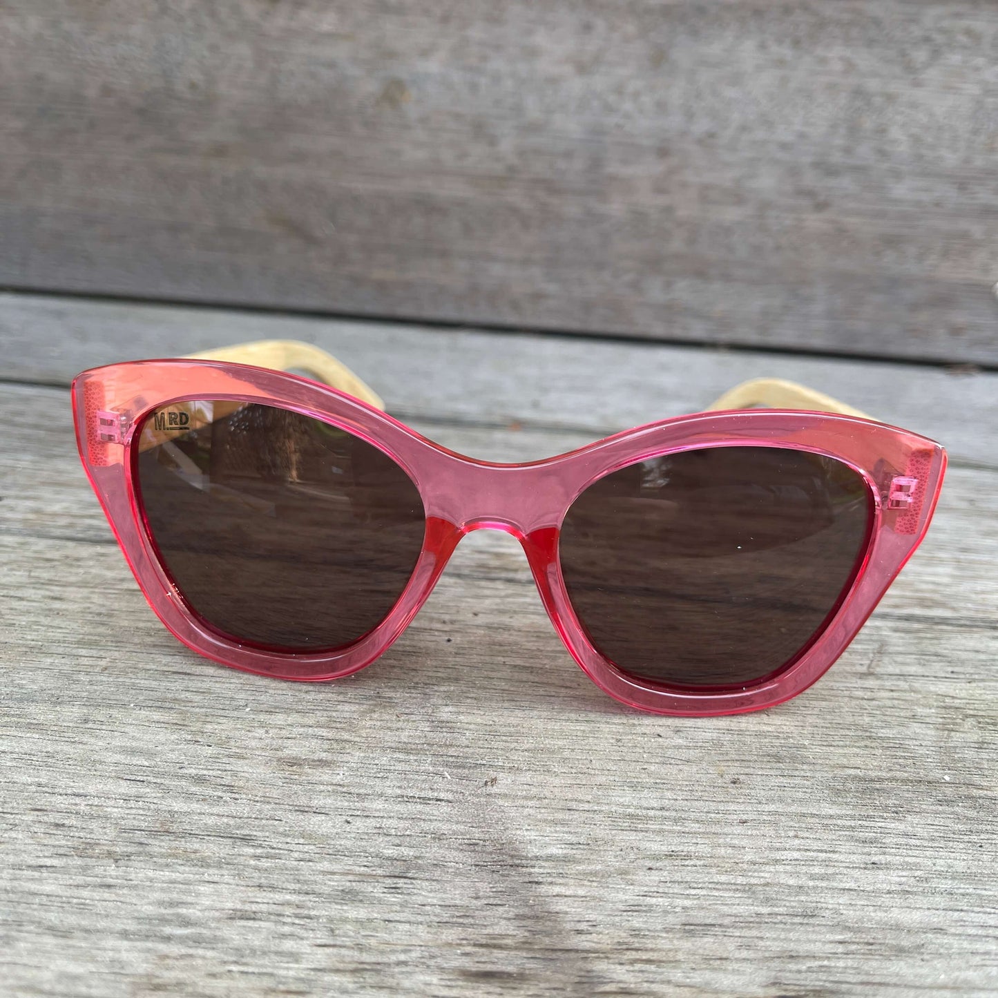 Womens sunglasses with pink frame and bamboo arms.