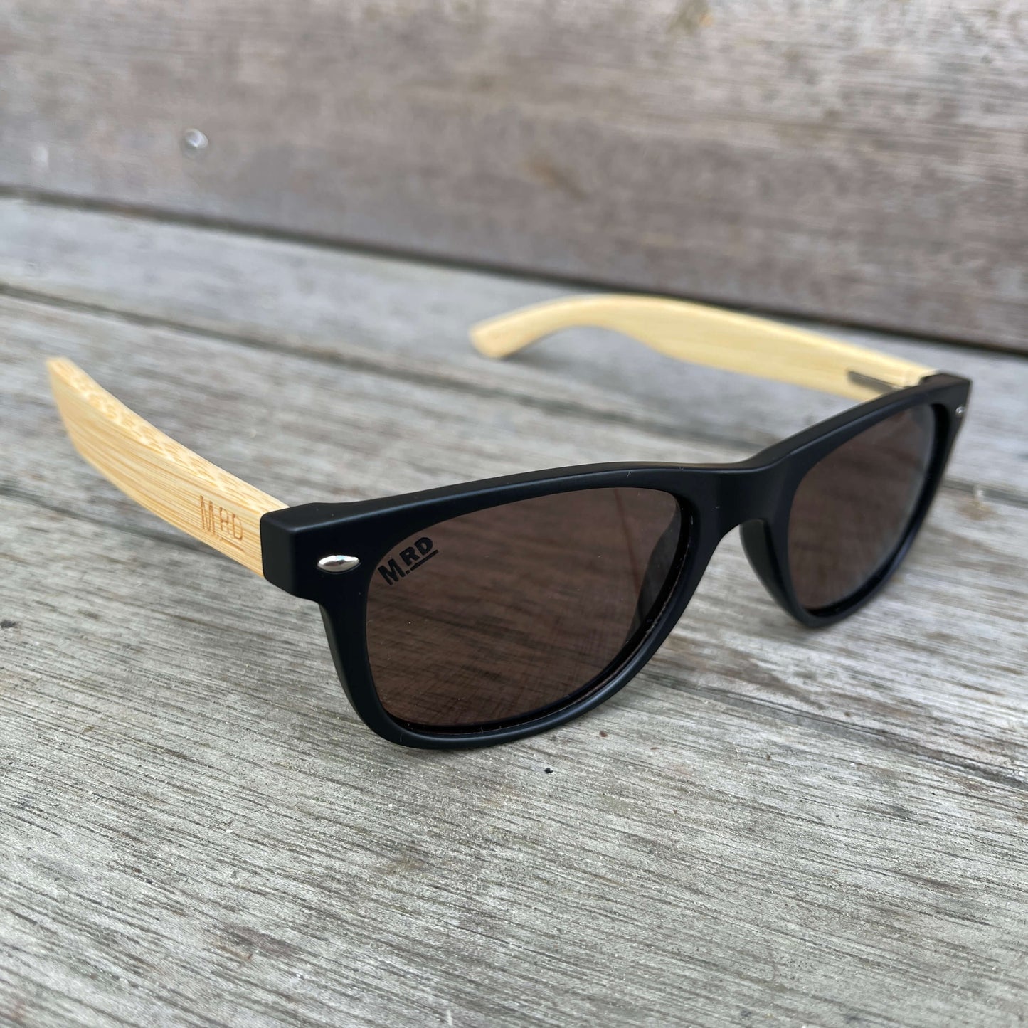 Kids sunglasses with black frame and wood arms.
