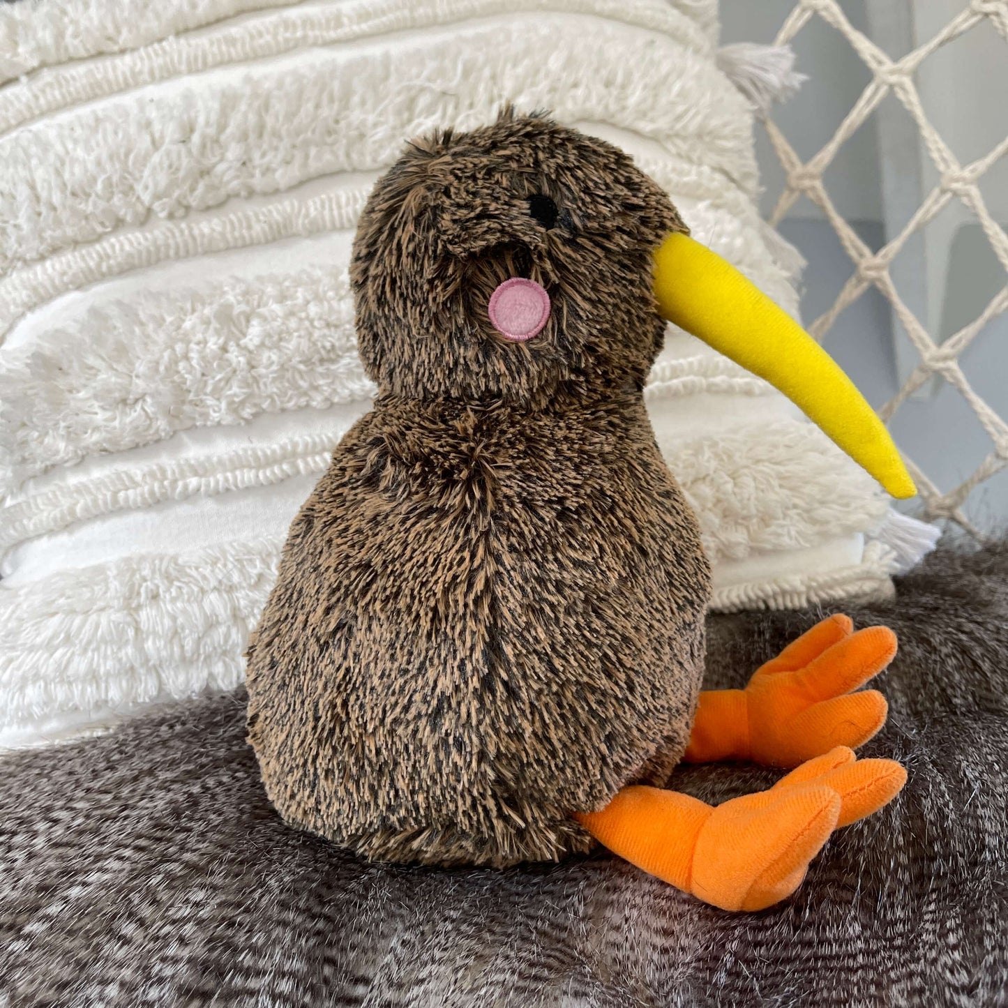 Soft toy Kiwi bird in brown with yellow beak and orange feet.