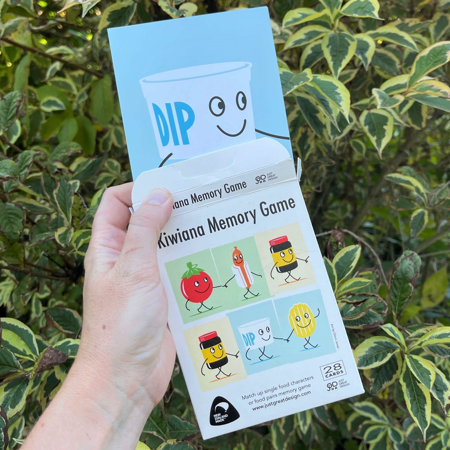 Women's hand holding cards for a New Zealand themed memory game.