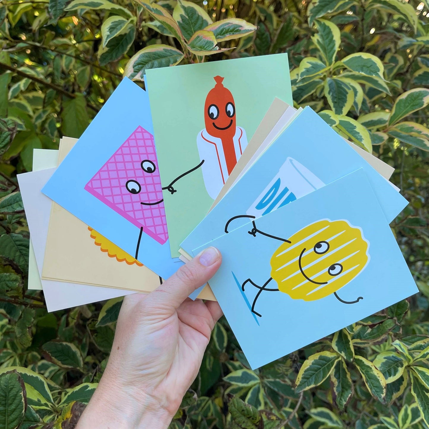 Women's hand holding cards for a New Zealand themed memory game.
