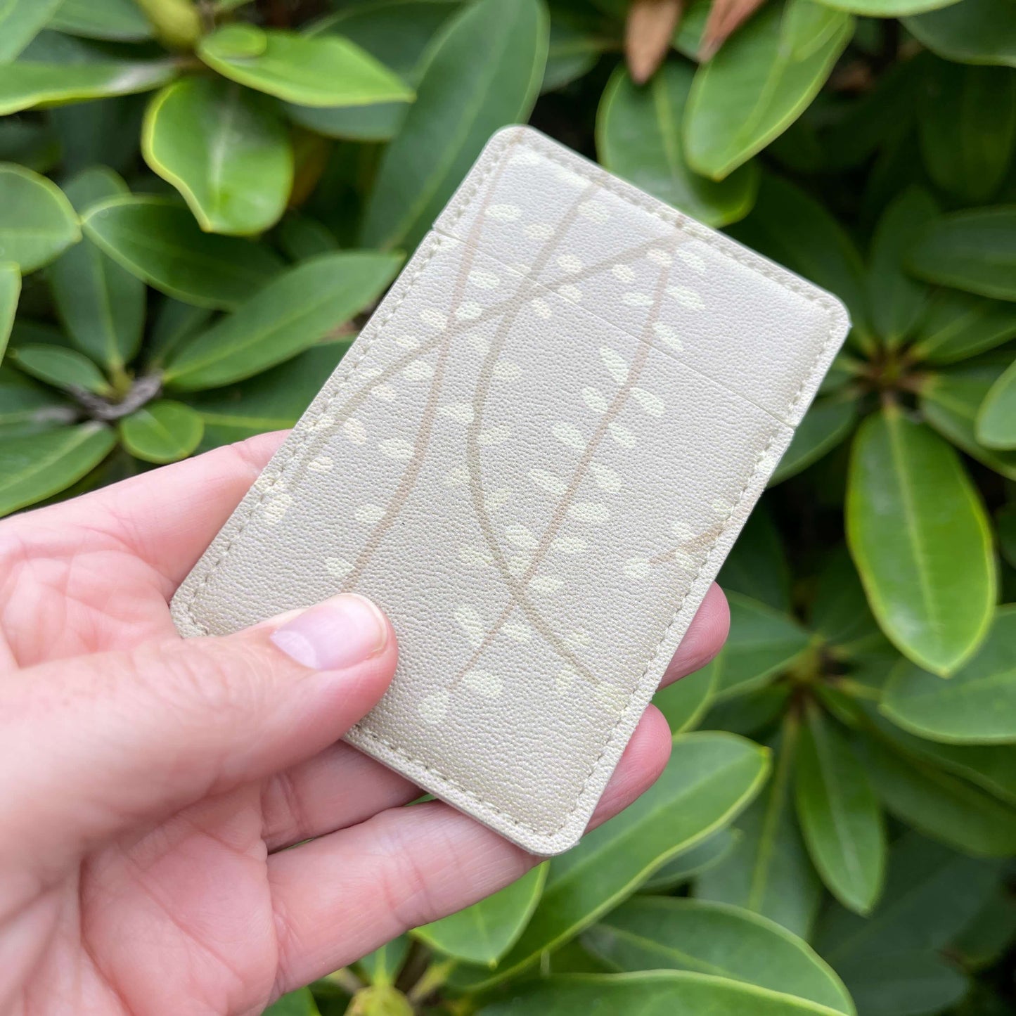 Pocket mirror featuring subtle beige Kowhai leaf against similar background. sini
