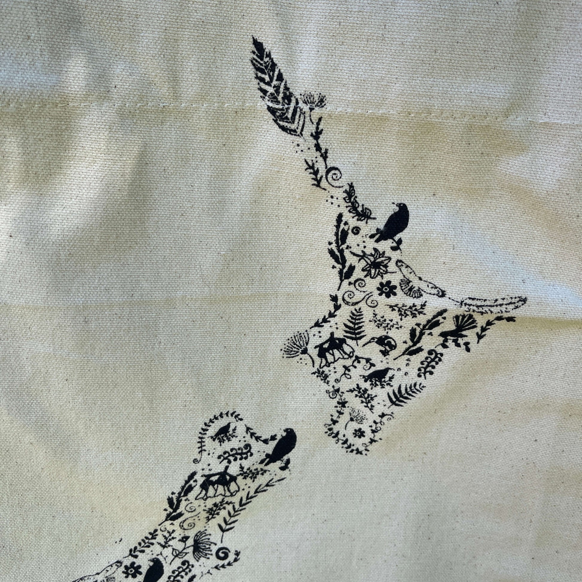Canvas tote bag with black floral map of NZ printed on it.