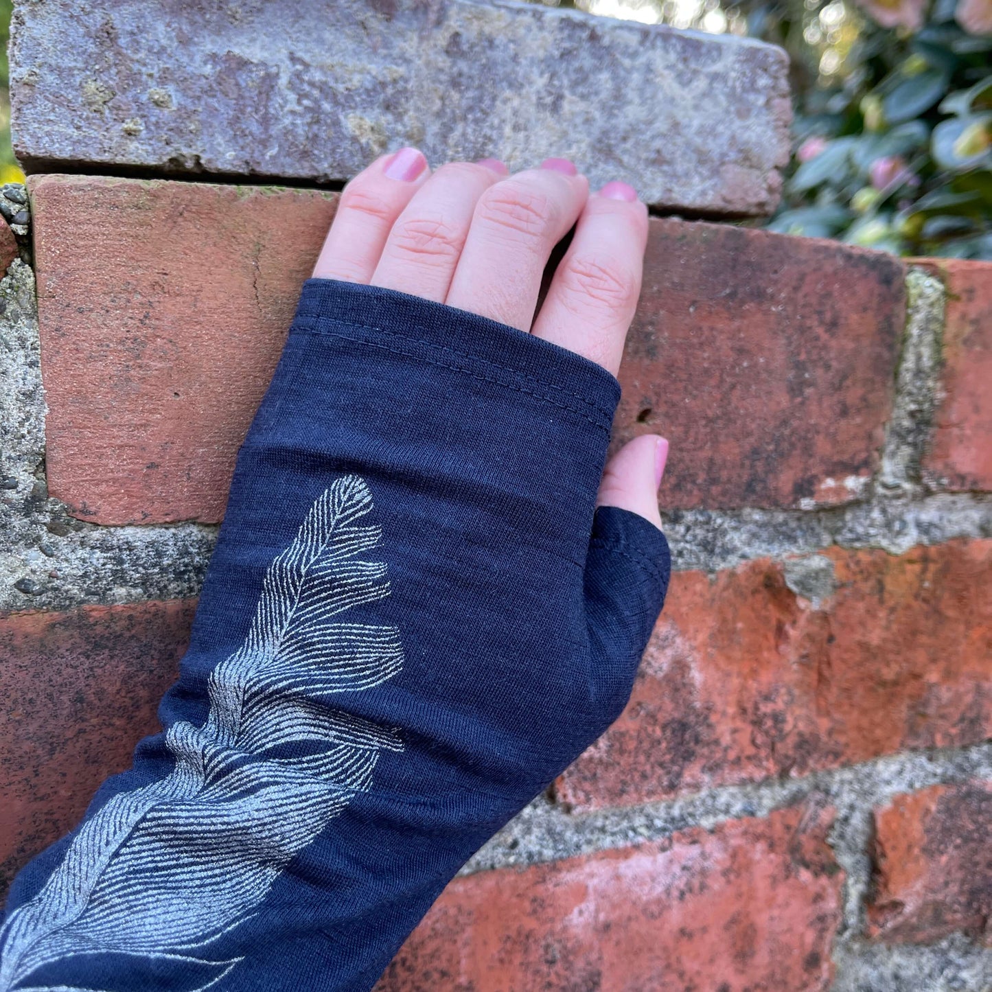 Fingerless merino gloves in navy with a silver feather print.