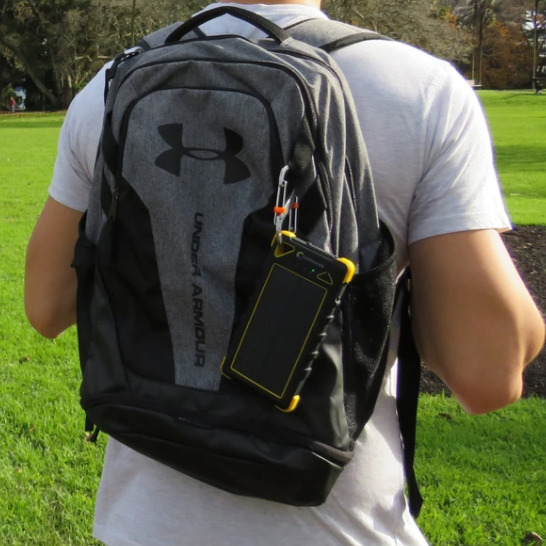 SunSaver Classic, 16,000mAh Solar Power Bank being charged by the sun and attached to a backpack.