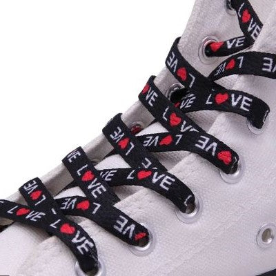 Black shoelaces with the word love printed on them and the O is a red heart.