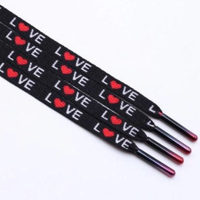 Black shoelaces with the word love printed on them and the O is a red heart.