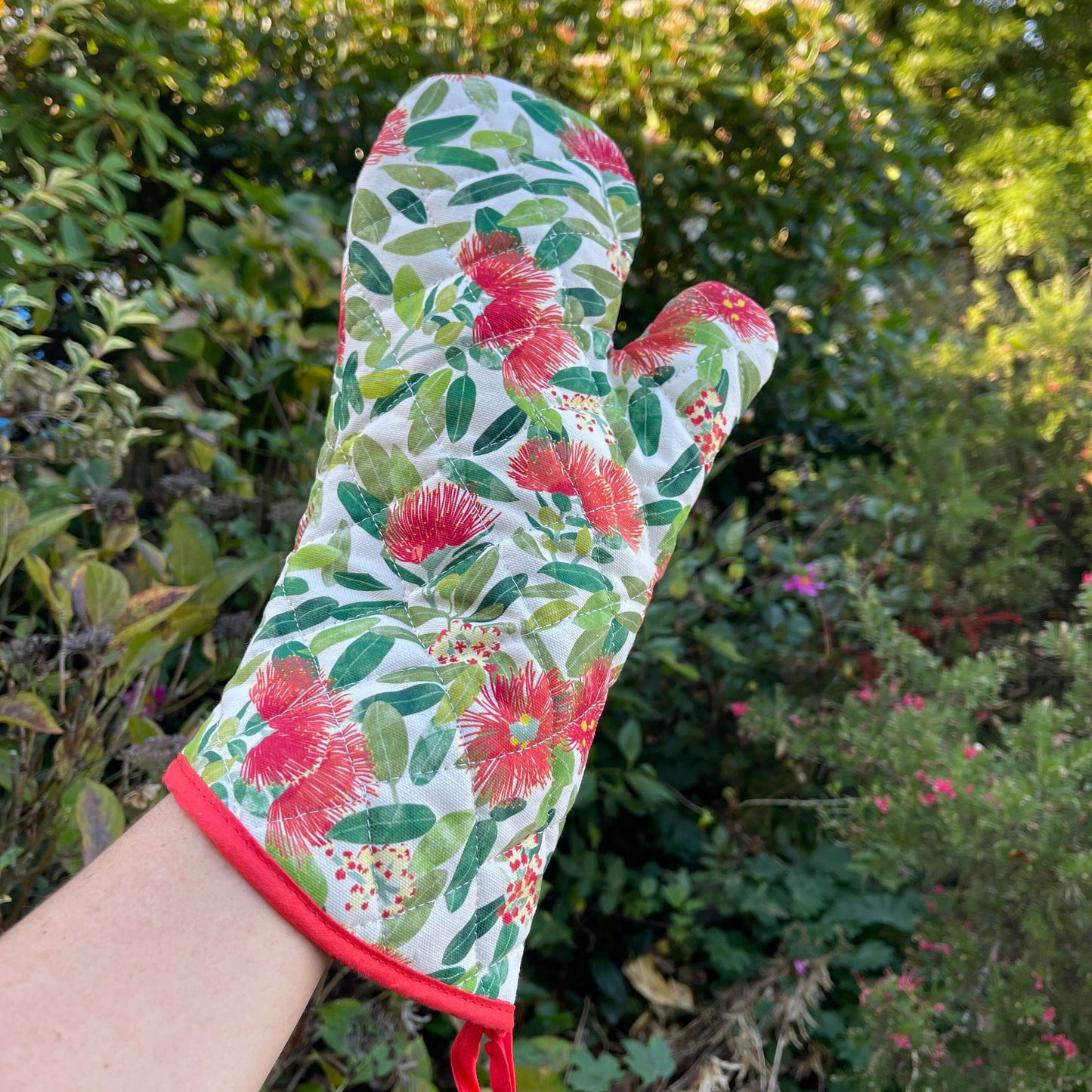 Pot mitt with Pohutukawa florwers printed on it.