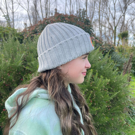 Child wearing grey knit beanie, side view.