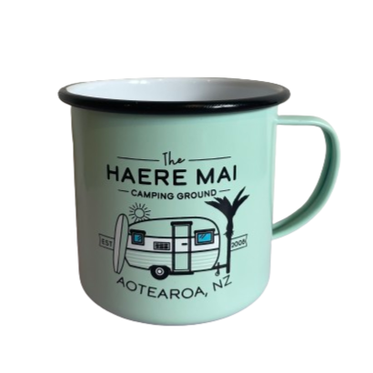 Mint green Haere Mai camping ground enamel mug with a caravan image on it.
