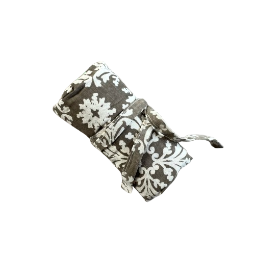 Taupe cotton tote bag with white floral decorative pattern rolled up and tied for storage.