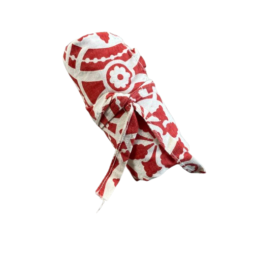 Red cotton tote bag with white floral decorative pattern rolled up for storage.