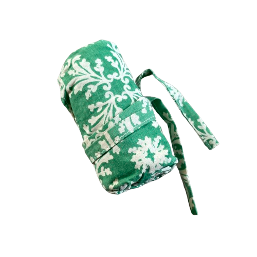 Green cotton tote bag with white floral decorative pattern rolled up and tied for storing.