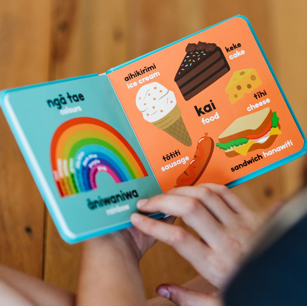Children's book with colorful illustrations of food and a rainbow held by a person.