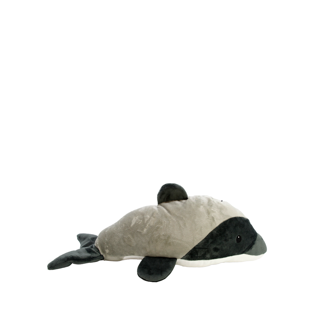 A plush Hectors dolphin toy lying on its side, featuring a light gray body, dark gray pectoral fins, dorsal fin, and tail, with a small white underbelly and a single visible eye.